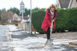 Councillor Isabelle MacKenzie clearing snow and ice in winter